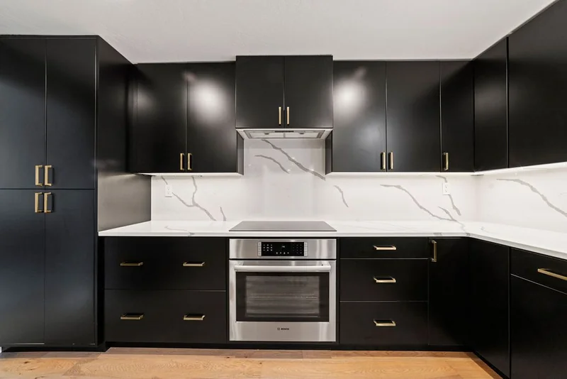 Custom black cabinets built around a wall oven and induction cooktop